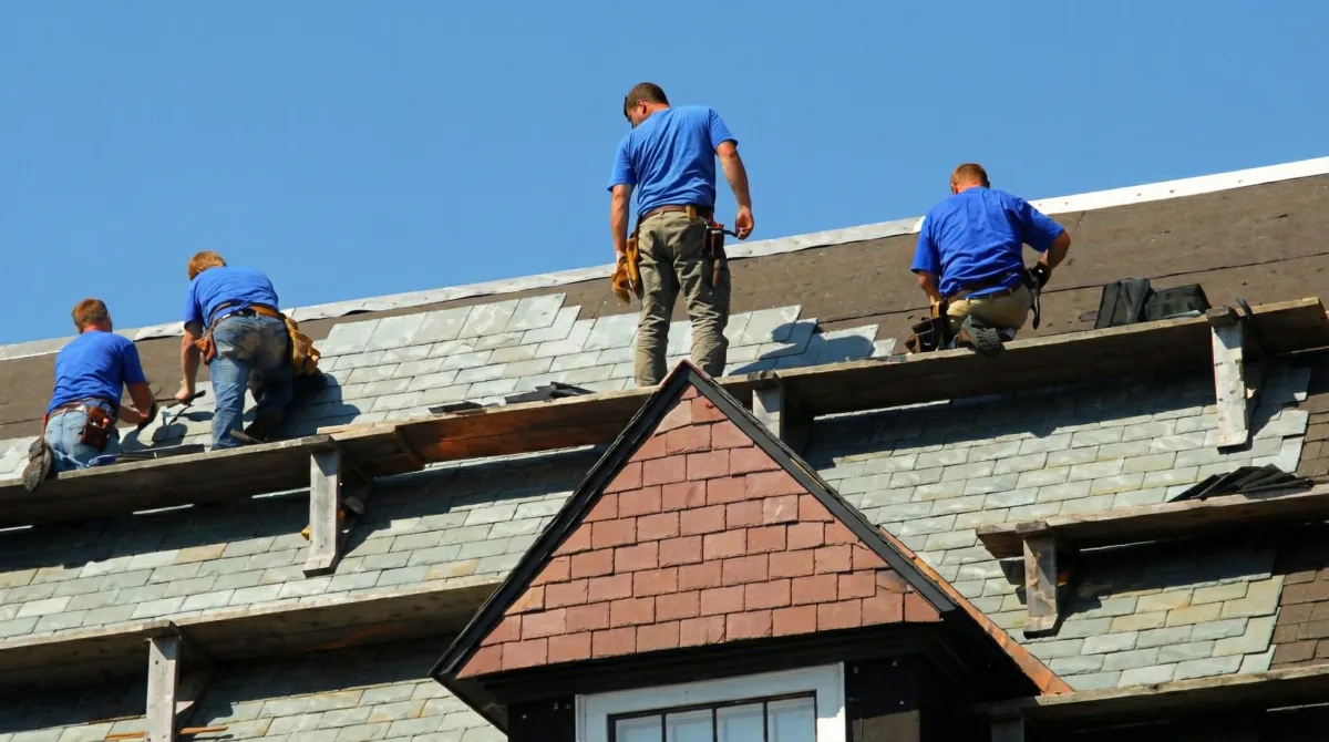 Roof replacement in progress with a team of professional contractors installing new shingles on a residential home in Aurora, IL
